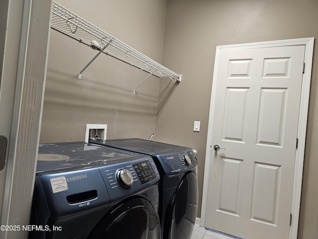 clothes washing area with laundry area, washer and dryer, and light tile patterned flooring