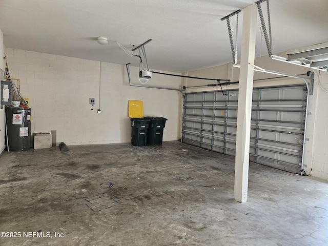 garage featuring a garage door opener, concrete block wall, and electric water heater