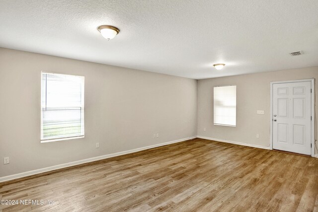 8956 3rd Ave, Jacksonville, FL 32208 - unfurnished room featuring light wood-style flooring, baseboards, and a textured ceiling