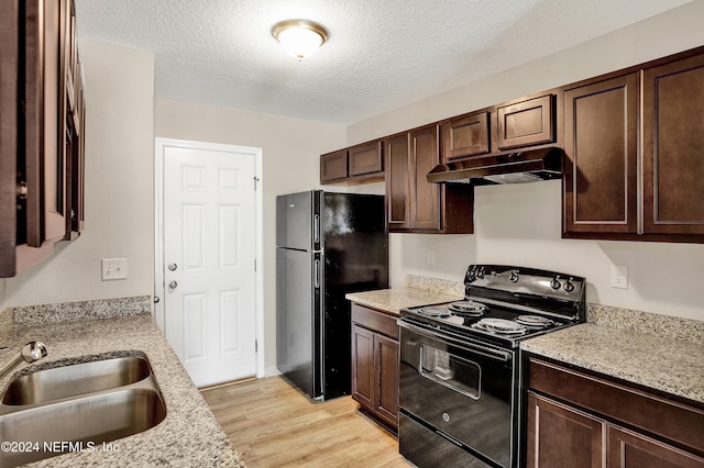 kitchen featuring light stone countertops, a textured ceiling, sink, black appliances, and light hardwood / wood-style floors