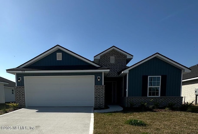 view of front of house with concrete driveway, brick siding, a front lawn, and an attached garage