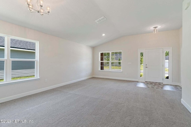 foyer entrance with a chandelier, light colored carpet, vaulted ceiling, and baseboards