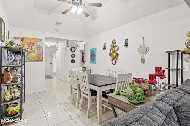 tiled dining room with ceiling fan, a textured ceiling, and vaulted ceiling