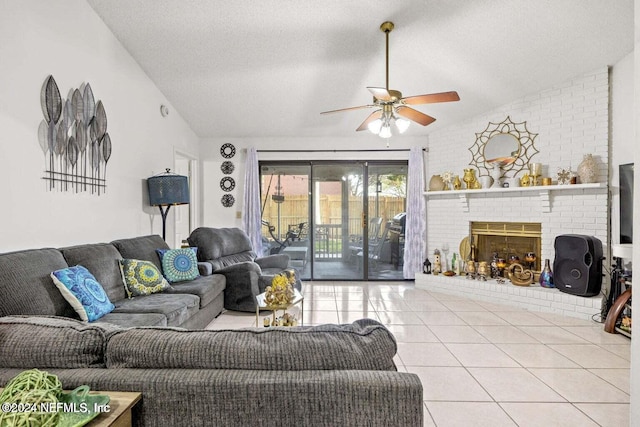 tiled living room with ceiling fan, a textured ceiling, lofted ceiling, and a brick fireplace