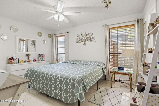 bedroom with a textured ceiling, multiple windows, and ceiling fan