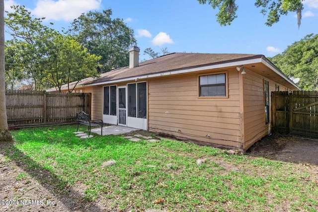 back of property with a patio area and a lawn