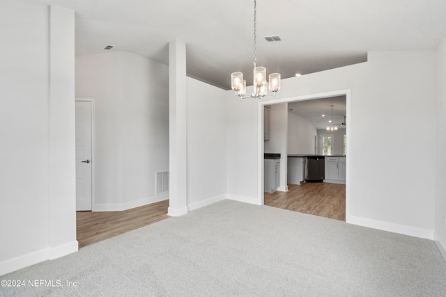 spare room featuring light carpet, a notable chandelier, and visible vents