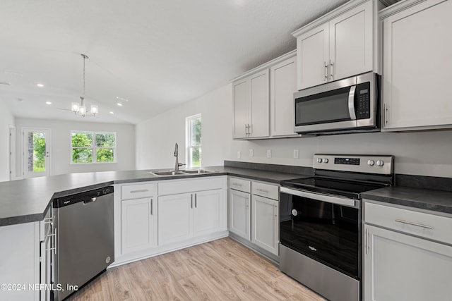 kitchen featuring dark countertops, white cabinetry, stainless steel appliances, and a sink