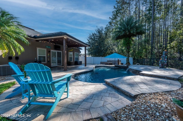 view of swimming pool with pool water feature, a patio area, and a hot tub