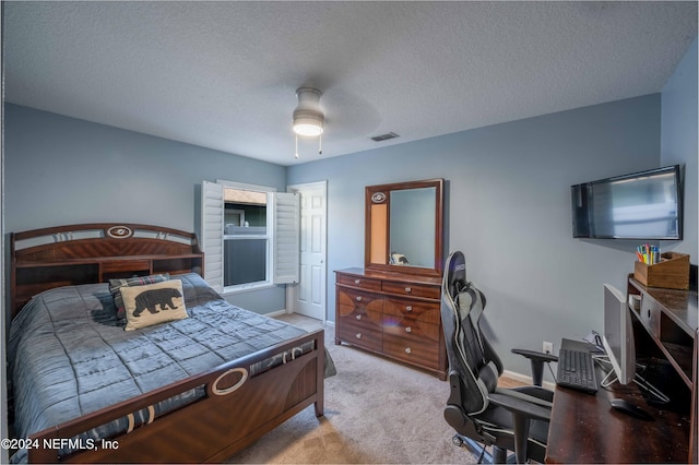 bedroom featuring light carpet, a textured ceiling, and ceiling fan