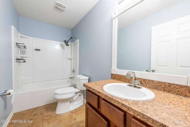 full bathroom with toilet, vanity, a textured ceiling, and tub / shower combination