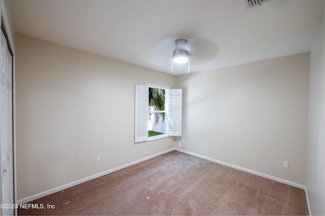 spare room featuring ceiling fan and carpet