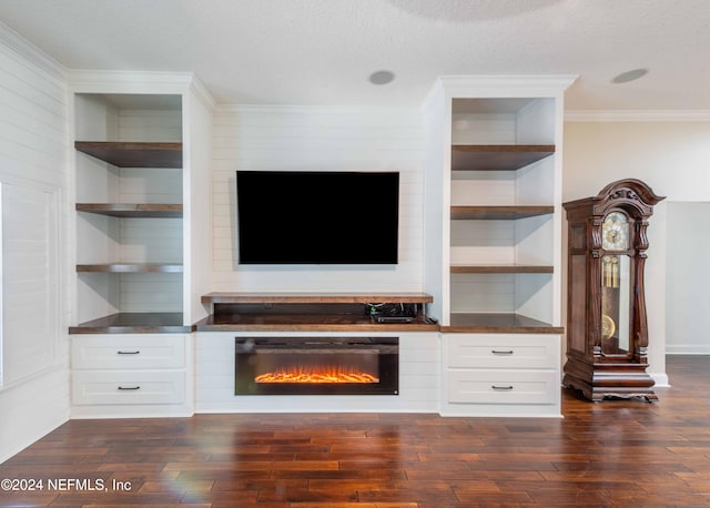 unfurnished living room featuring dark hardwood / wood-style flooring, a textured ceiling, built in features, and ornamental molding