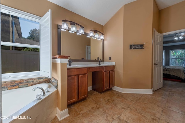 bathroom featuring tile patterned flooring, a bath, vanity, and lofted ceiling