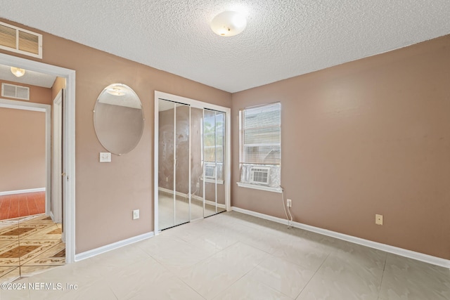 unfurnished bedroom featuring a closet and a textured ceiling