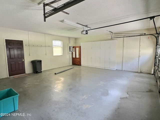 garage with electric panel and a garage door opener