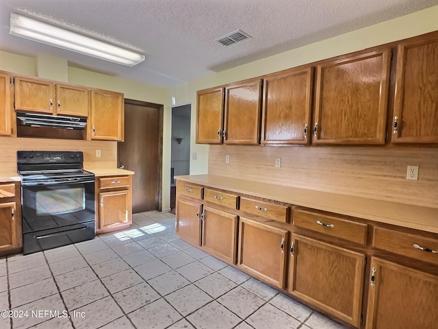 kitchen with a textured ceiling, black / electric stove, light tile patterned floors, and backsplash