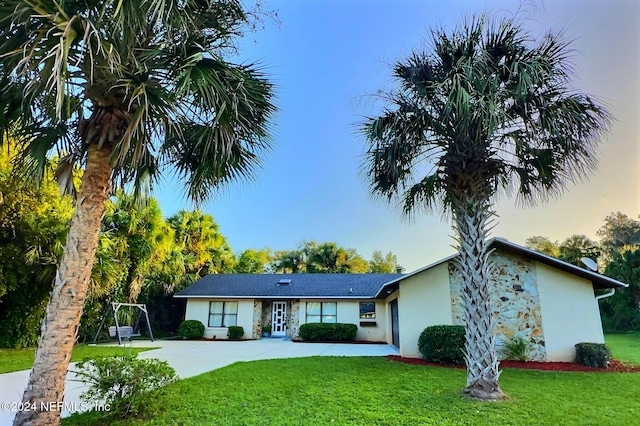 ranch-style home with a lawn