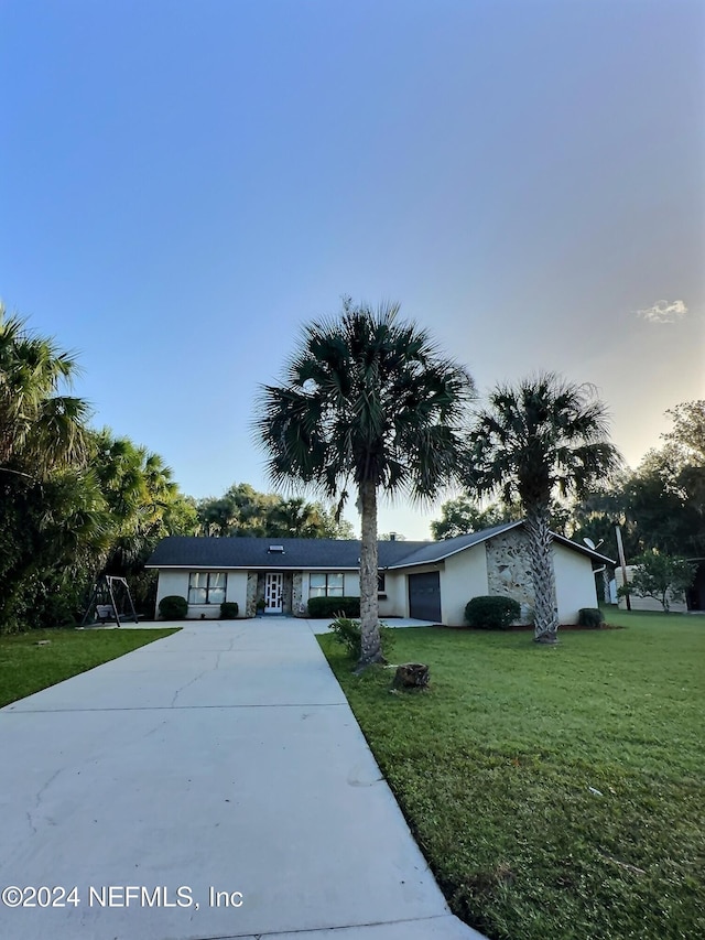 ranch-style home with a lawn