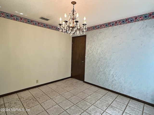 unfurnished room with a chandelier