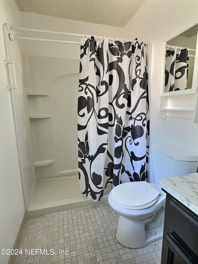 bathroom with toilet, curtained shower, and vanity