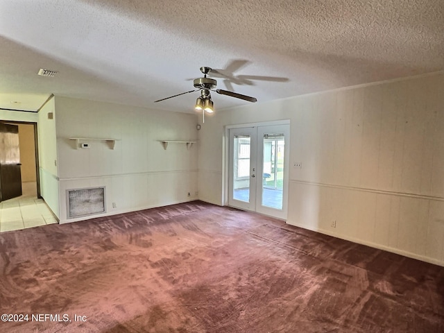 spare room with french doors, ceiling fan, carpet flooring, and a textured ceiling