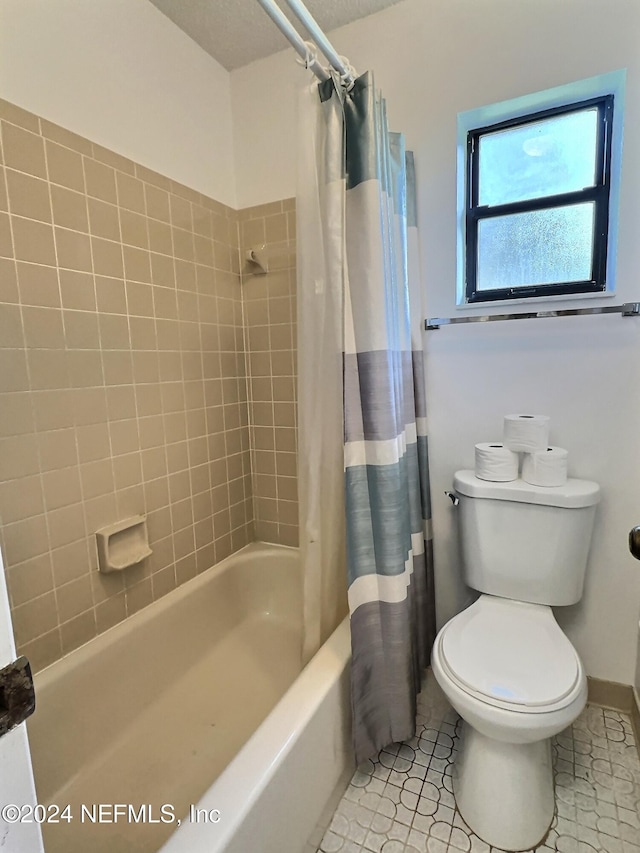 bathroom featuring shower / bath combination with curtain, toilet, and tile patterned flooring