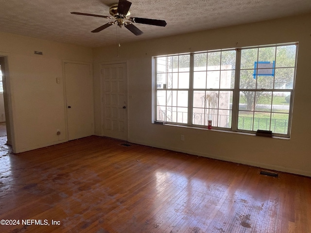 spare room with a wealth of natural light and hardwood / wood-style flooring