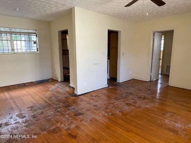 empty room featuring a textured ceiling, wood-type flooring, and ceiling fan