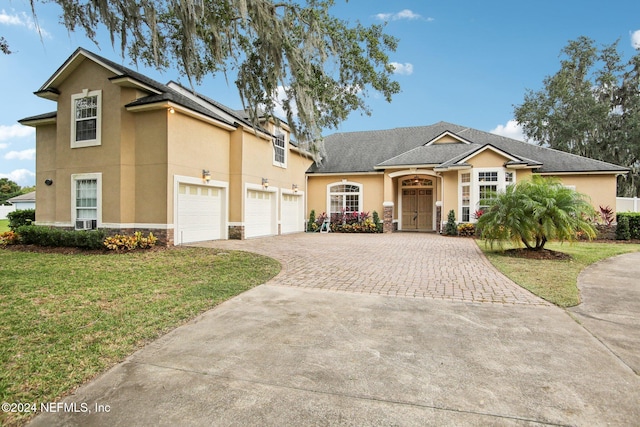 front of property with a garage and a front lawn