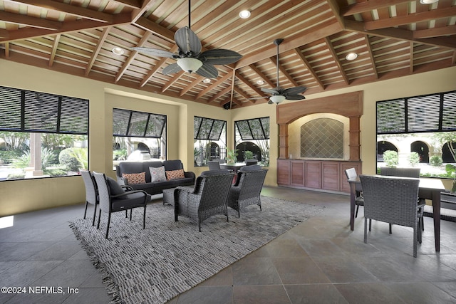 sunroom / solarium featuring ceiling fan, vaulted ceiling with beams, and wood ceiling