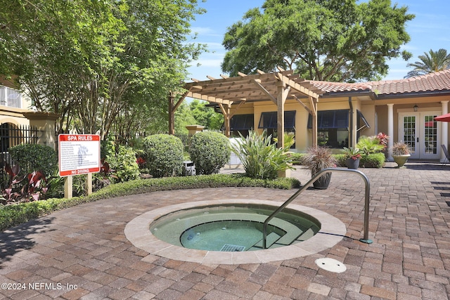 view of swimming pool with a pergola, a hot tub, and french doors