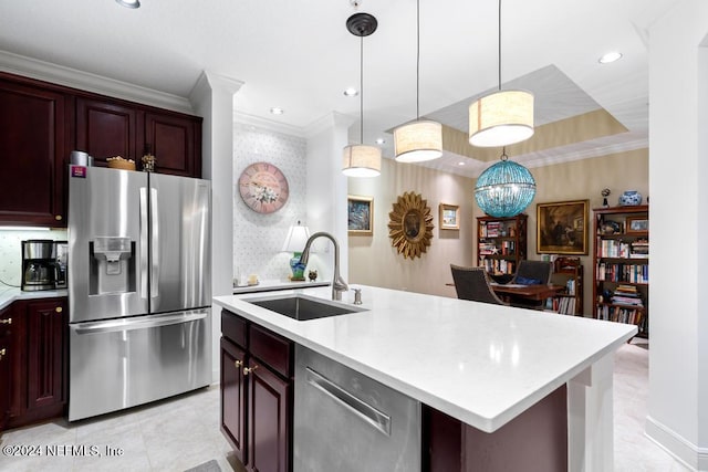 kitchen with pendant lighting, sink, ornamental molding, stainless steel appliances, and a center island with sink