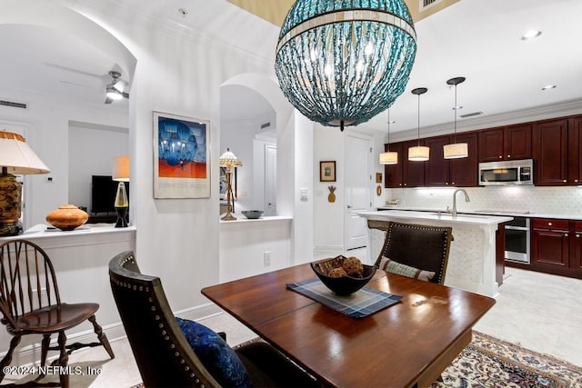 dining area with crown molding and ceiling fan