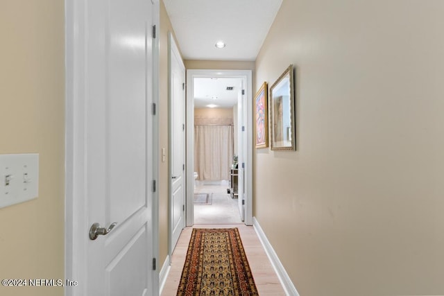 corridor with hardwood / wood-style flooring