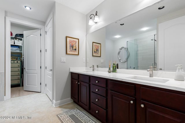 bathroom with vanity, a shower with shower door, and tile patterned floors