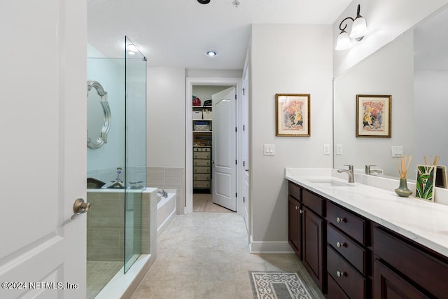 bathroom featuring tile patterned flooring, vanity, and separate shower and tub