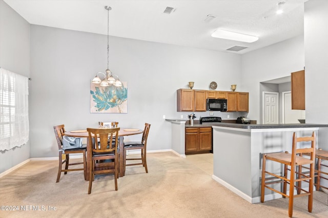 kitchen featuring pendant lighting, kitchen peninsula, light colored carpet, and a kitchen breakfast bar