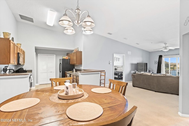 carpeted dining area with sink, lofted ceiling, and ceiling fan with notable chandelier