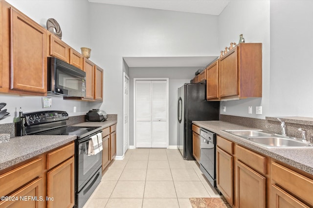 kitchen featuring light tile patterned floors, black appliances, and sink