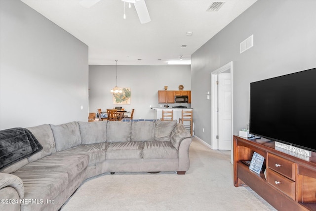 carpeted living room with ceiling fan