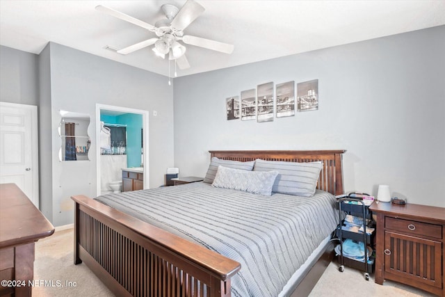 bedroom featuring light carpet, ensuite bath, and ceiling fan