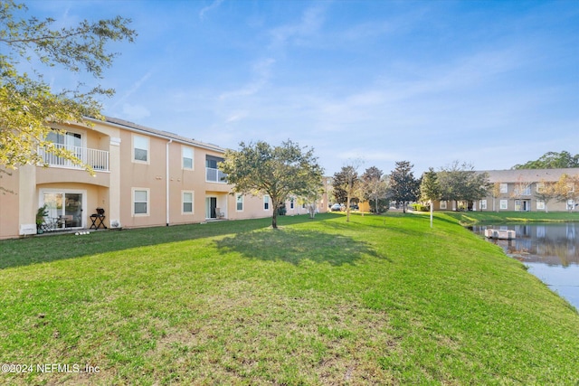 view of yard featuring a water view and a balcony