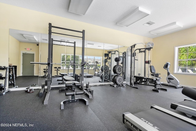 gym with a textured ceiling and plenty of natural light