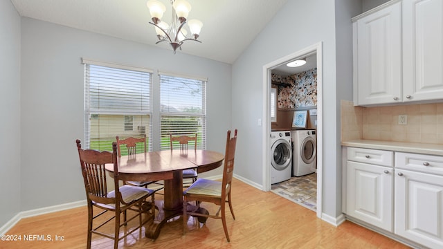 dining area with light hardwood / wood-style floors, a notable chandelier, vaulted ceiling, and washer and clothes dryer