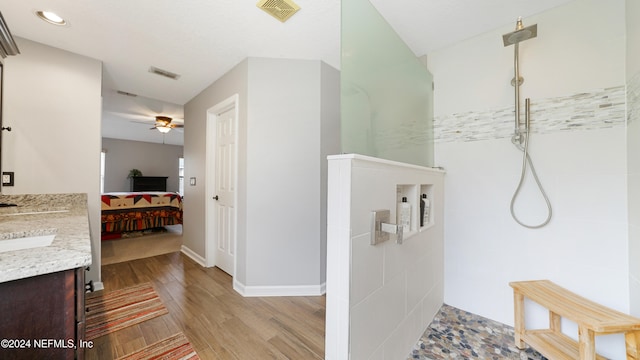 bathroom featuring vanity, ceiling fan, wood-type flooring, and walk in shower