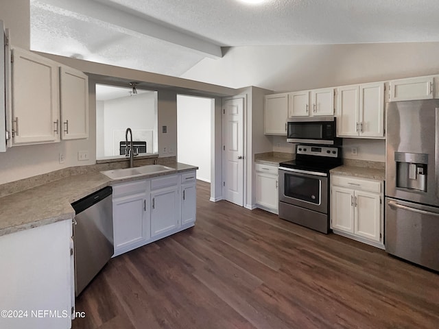 kitchen with white cabinetry, stainless steel appliances, and vaulted ceiling with beams