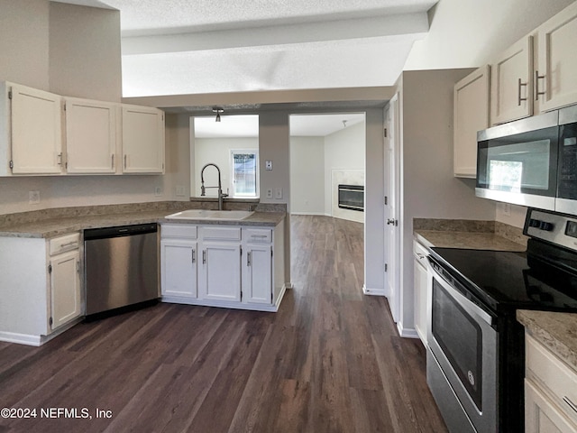 kitchen featuring appliances with stainless steel finishes, white cabinetry, and sink