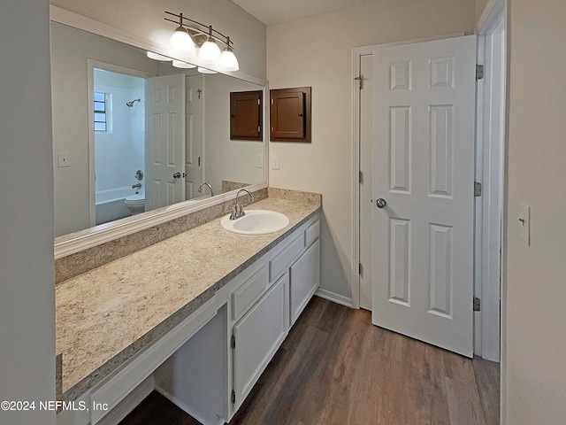 bathroom featuring vanity, hardwood / wood-style flooring, and bathing tub / shower combination