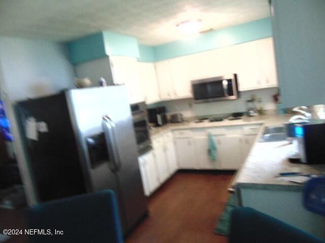 kitchen with cooktop, oven, fridge with ice dispenser, white cabinets, and dark hardwood / wood-style floors